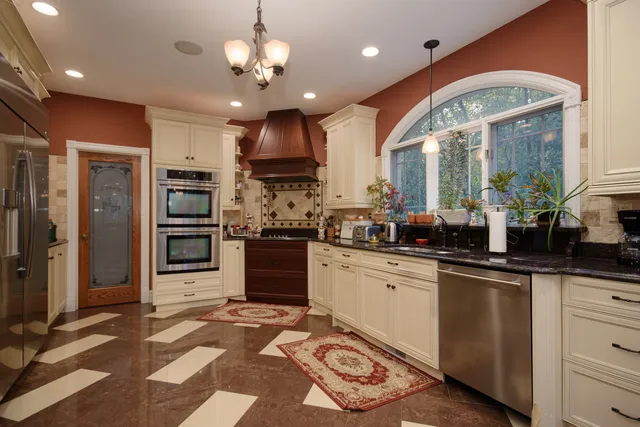 a kitchen with stainless steel appliances granite countertop a sink a stove and a refrigerator