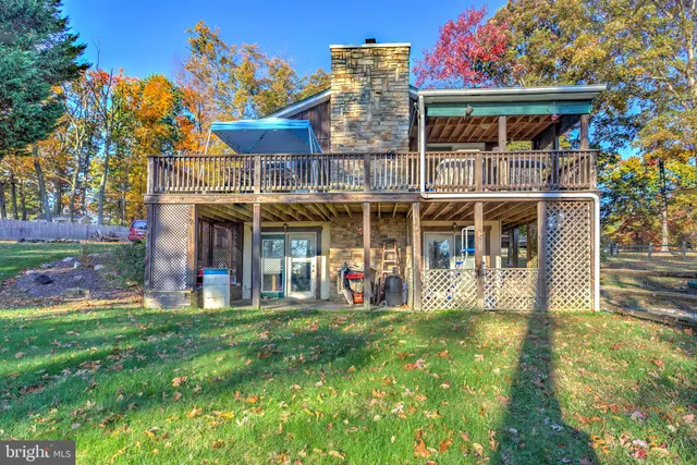 a view of a small house with a small yard and wooden fence