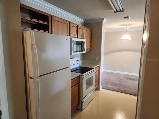 a white refrigerator freezer and a stove sitting inside of a kitchen