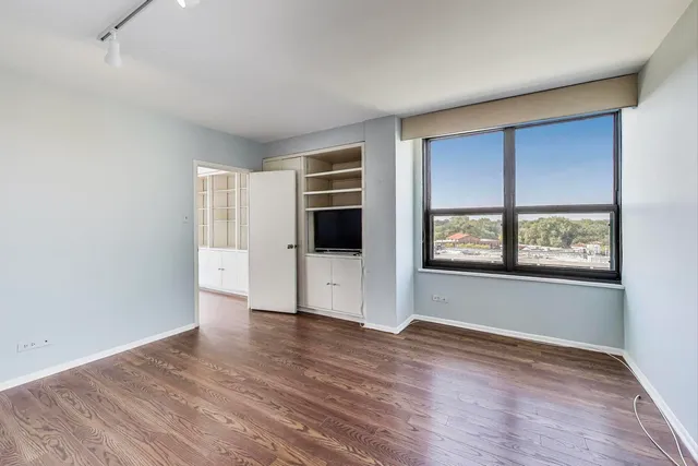 a bedroom with a large bed a chandelier and closet