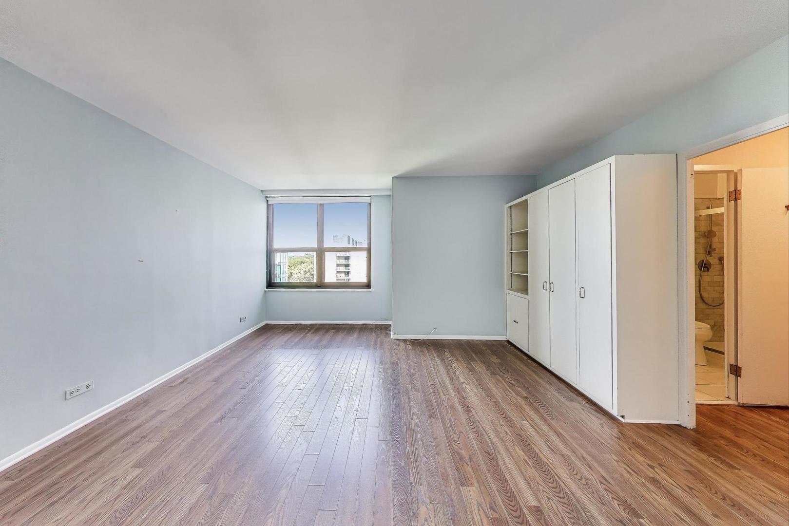 1616 Sheridan Road, Unit 9H Wilmette, IL 60091 - Photo 15 of 28 an empty room with wooden floor and windows