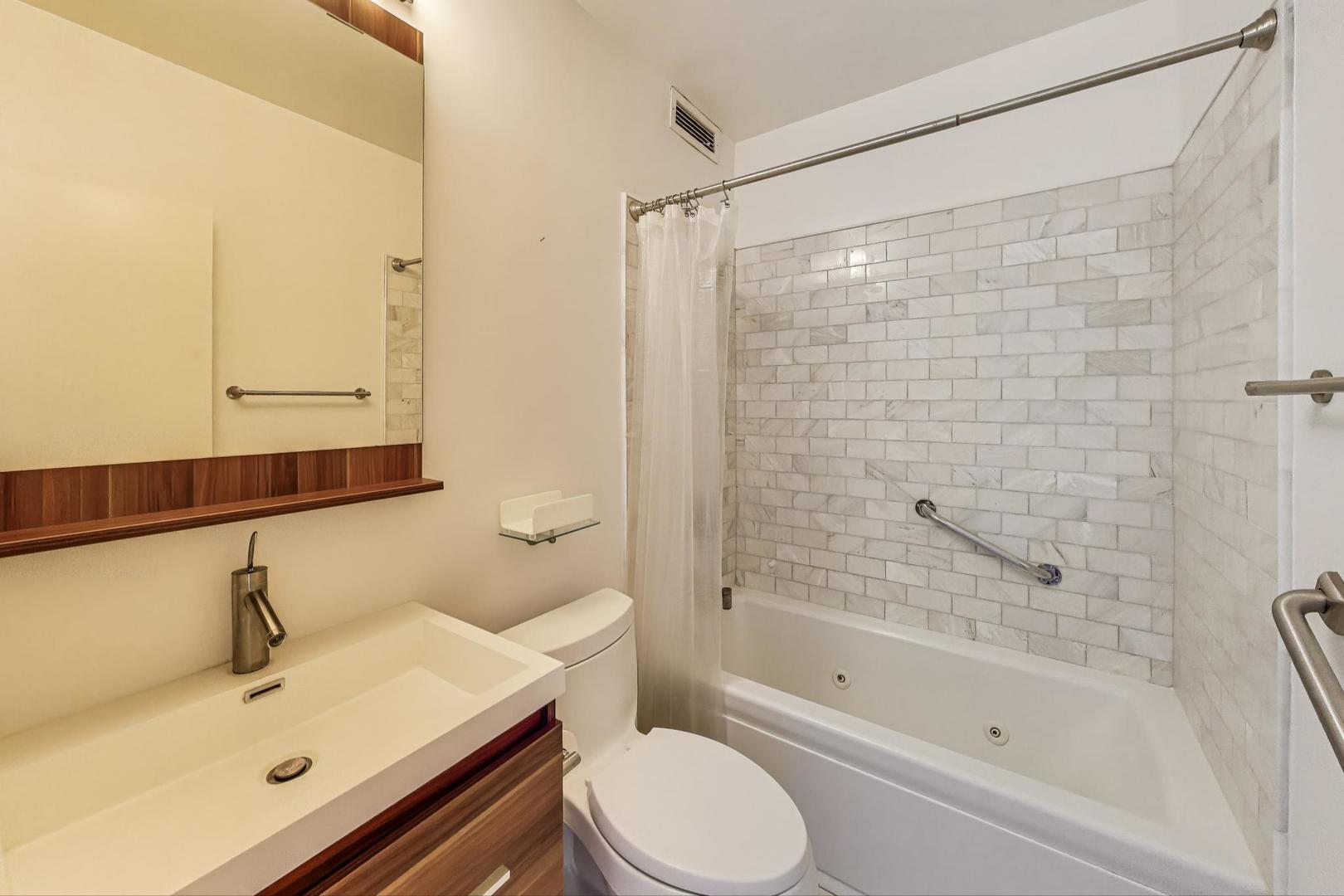 1616 Sheridan Road, Unit 9H Wilmette, IL 60091 - Photo 19 of 28 a bathroom with a sink mirror toilet and bathtub