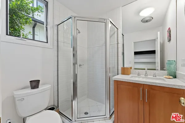 a bathroom with a granite countertop sink toilet and shower