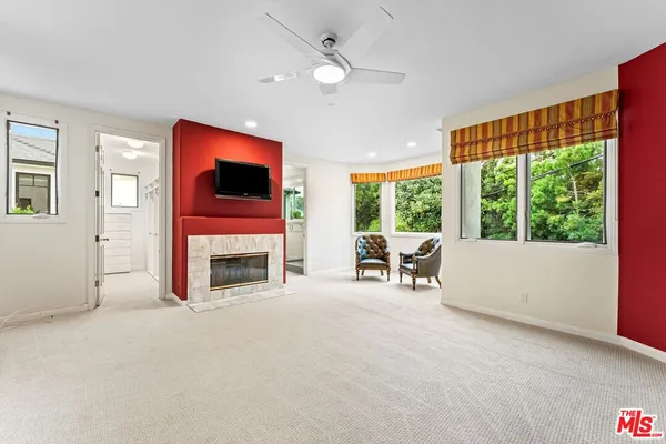 a living room with fireplace furniture and a large window