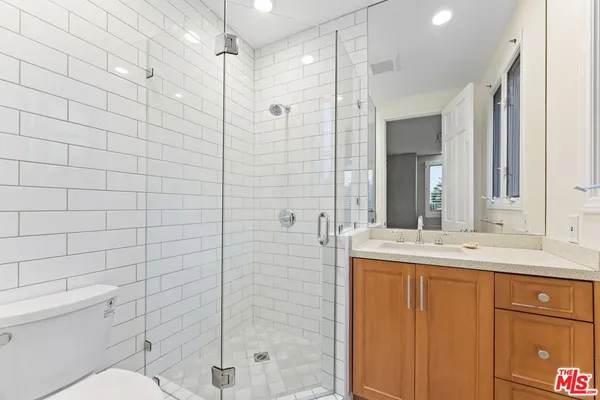 a bathroom with a granite countertop sink toilet and shower