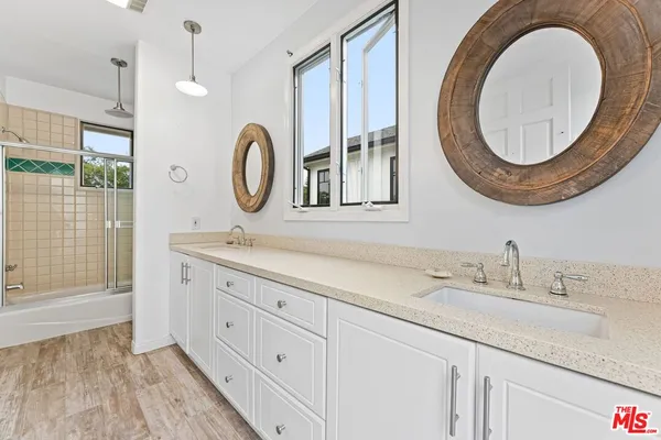 a bathroom with a granite countertop double vanity sink and a mirror