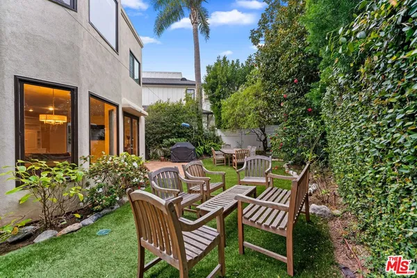 a view of backyard with outdoor seating and green space