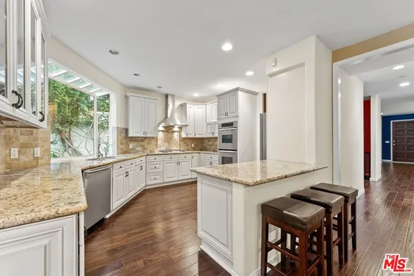 a kitchen with granite countertop kitchen island wooden cabinets a counter and a sink