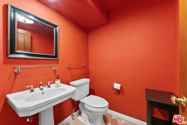 a bathroom with a toilet sink and mirror