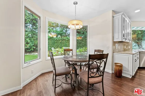 a dining room with furniture a chandelier and wooden floor