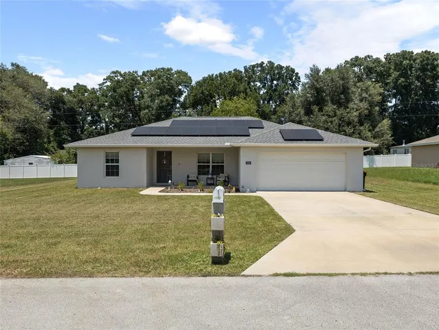 a front view of house with yard and trees in the background