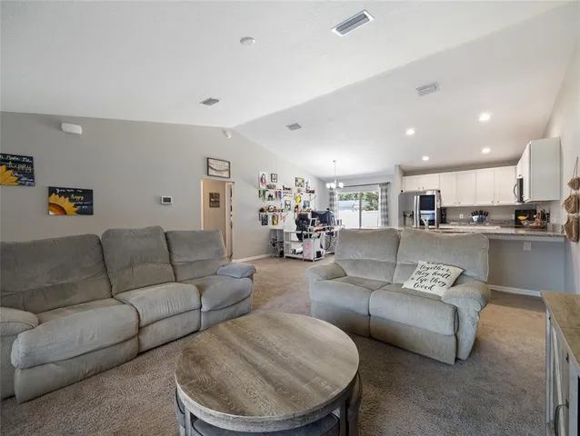 a living room with furniture and kitchen view
