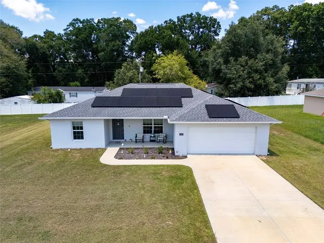 a front view of house with yard and trees in the background