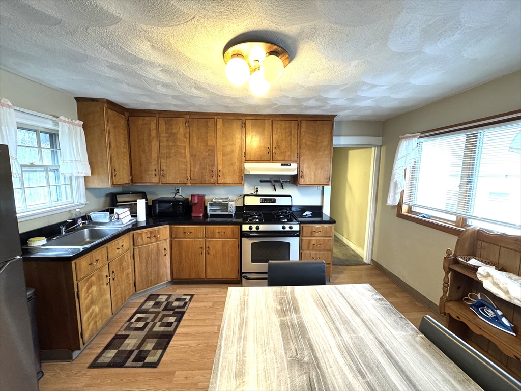30 Thorpe Street, Unit 2 Somerville, MA 02143 - Photo 1 of 9 a kitchen with a stove a sink a refrigerator cabinets and a window