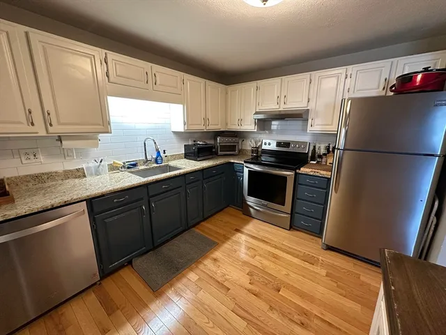 a kitchen with stainless steel appliances granite countertop a refrigerator sink and stove