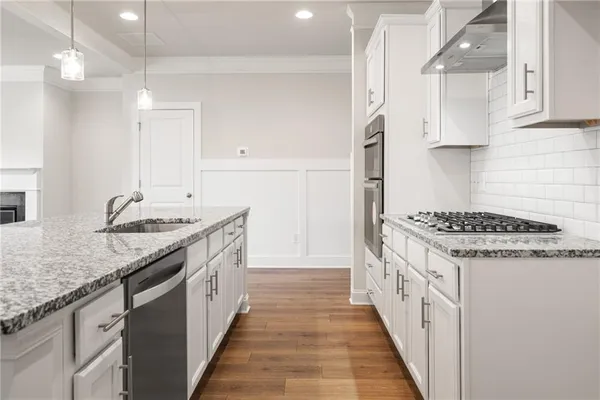 a kitchen with granite countertop a sink stove and cabinets