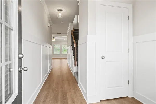 a view of a hallway with wooden floor and staircase