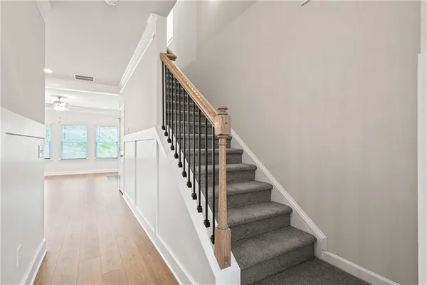 a view of staircase with wooden floor and white walls