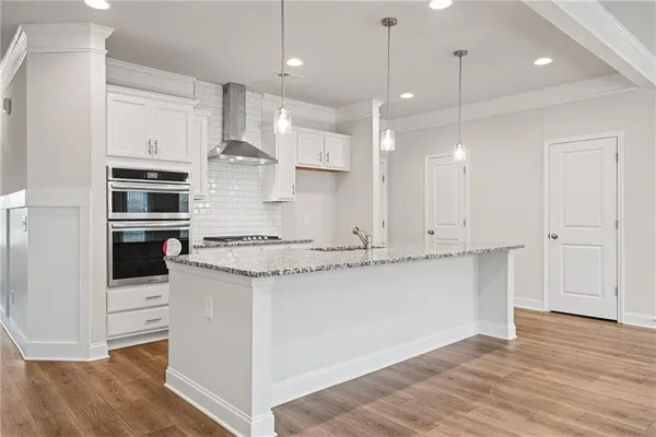 a kitchen with stainless steel appliances granite countertop a sink and a refrigerator