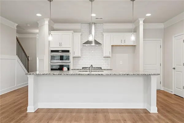 a large kitchen with granite countertop a large counter top space a sink stainless steel appliances and cabinets