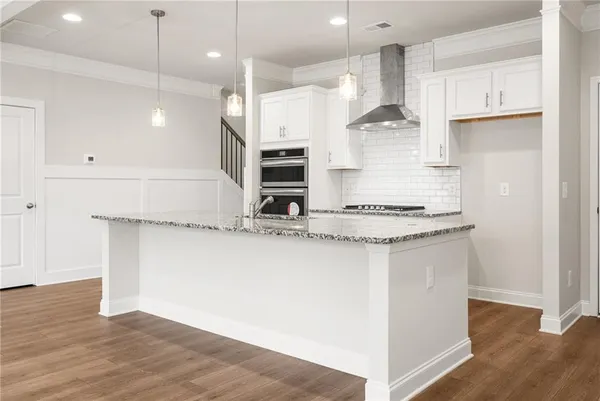 a kitchen with kitchen island a counter top space a sink stainless steel appliances and cabinets