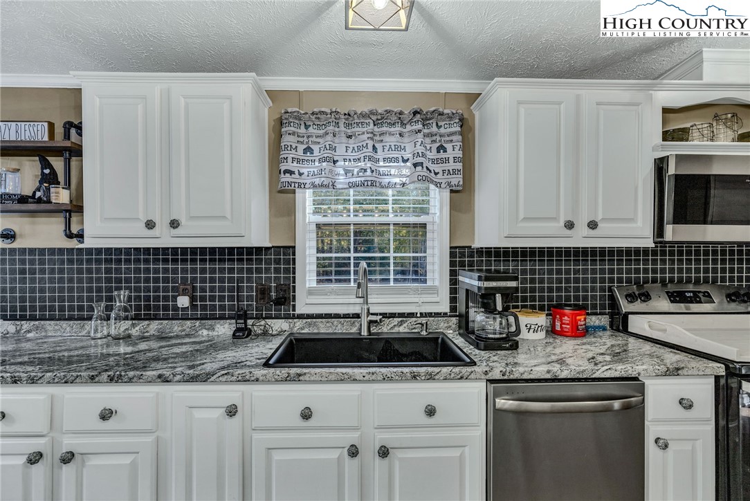 1108 Bald Knob Road Sparta, NC 28675 - Photo 30 of 43 a kitchen with granite countertop a sink stove and cabinets