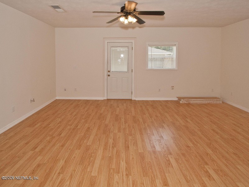 221 Swallow Road St. Augustine, FL 32086 - Photo 11 of 17 an empty room with wooden floor chandelier fan and windows