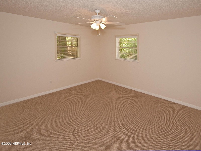 221 Swallow Road St. Augustine, FL 32086 - Photo 6 of 17 an empty room with windows and chandelier fan