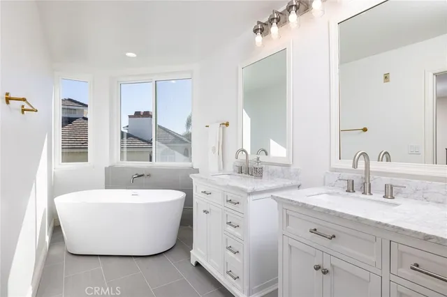 a spacious bathroom with a double vanity sink mirror and bathtub