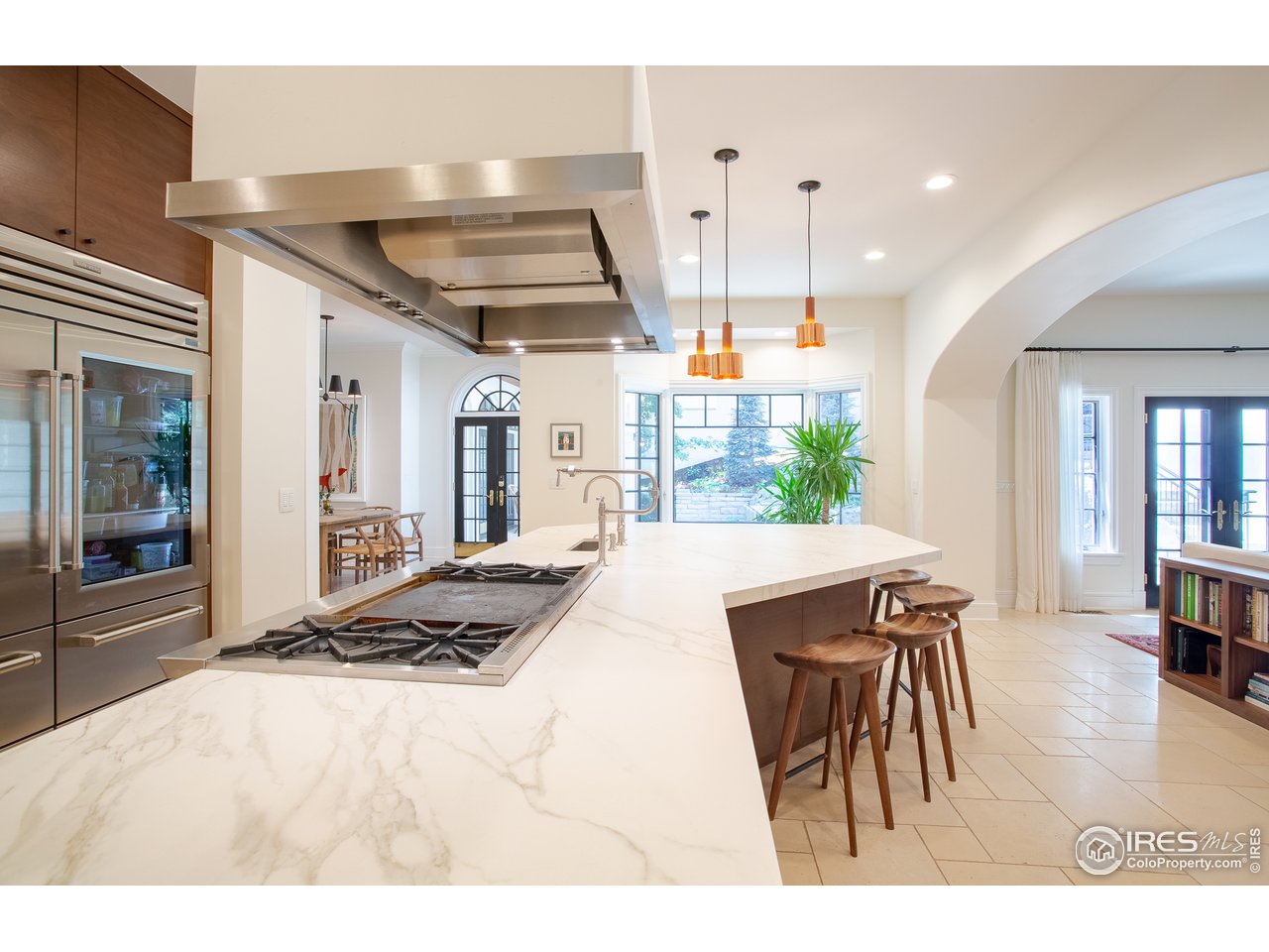 985 Gilbert Street Boulder, CO 80302 - Photo 7 of 40 a open kitchen with granite countertop a stove a sink a dining table and chairs with wooden floor
