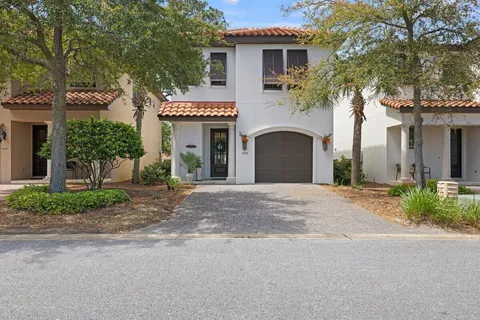 a front view of a house with garden and garage