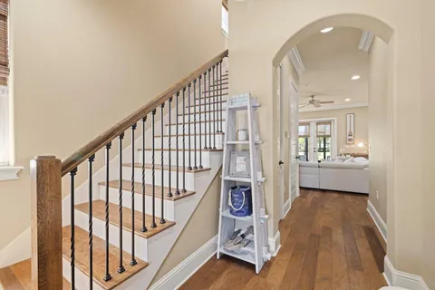 a view of a hallway with wooden floor and staircase