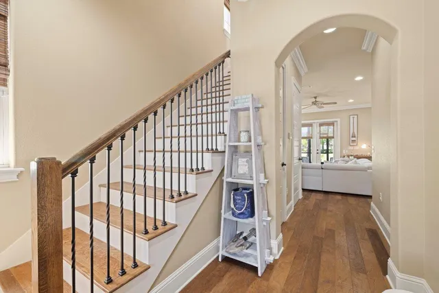 a view of a hallway with wooden floor and staircase