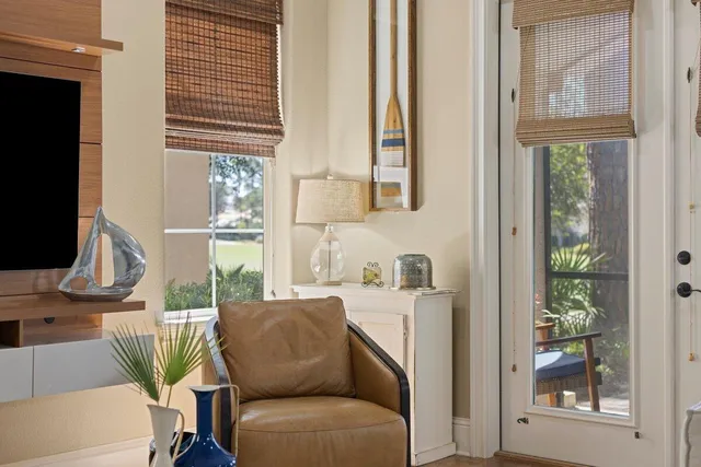 a living room with furniture a flat screen tv and a window