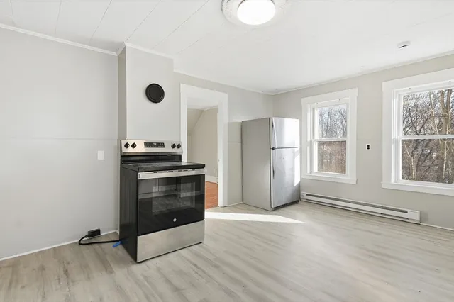 a view of a kitchen with wooden floor and electronic appliances