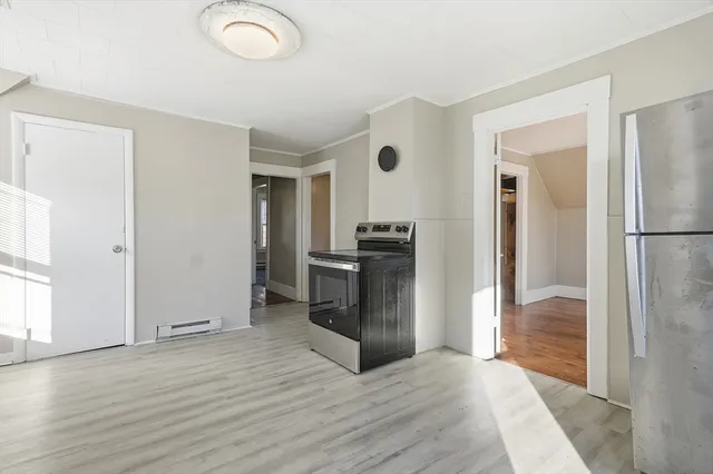 a view of a kitchen with wooden floor and a window