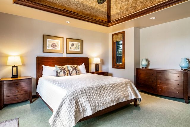 a bedroom with a bed and lamp on dresser