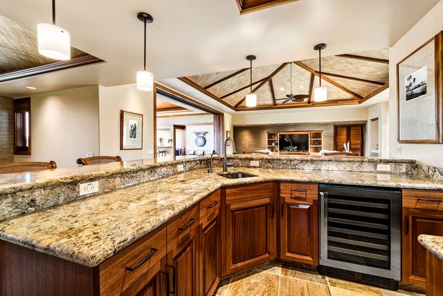 a kitchen with granite countertop a sink and a wooden floor