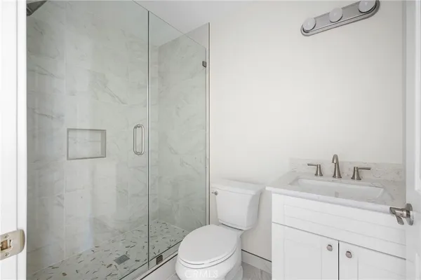 a bathroom with a toilet sink vanity and shower