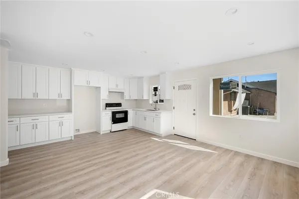 a view of a kitchen with wooden floor and electronic appliances