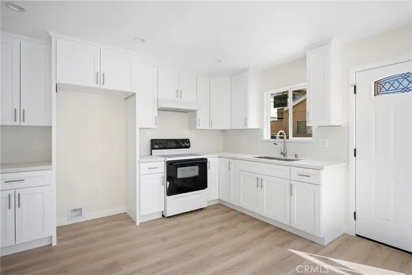 a kitchen with white cabinets and white appliances