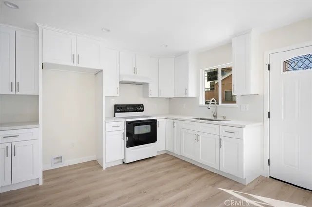 a kitchen with white cabinets and white appliances