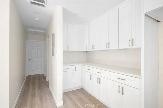 a view of a kitchen with white cabinets