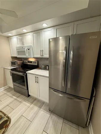 a kitchen with stainless steel appliances a refrigerator sink and cabinets