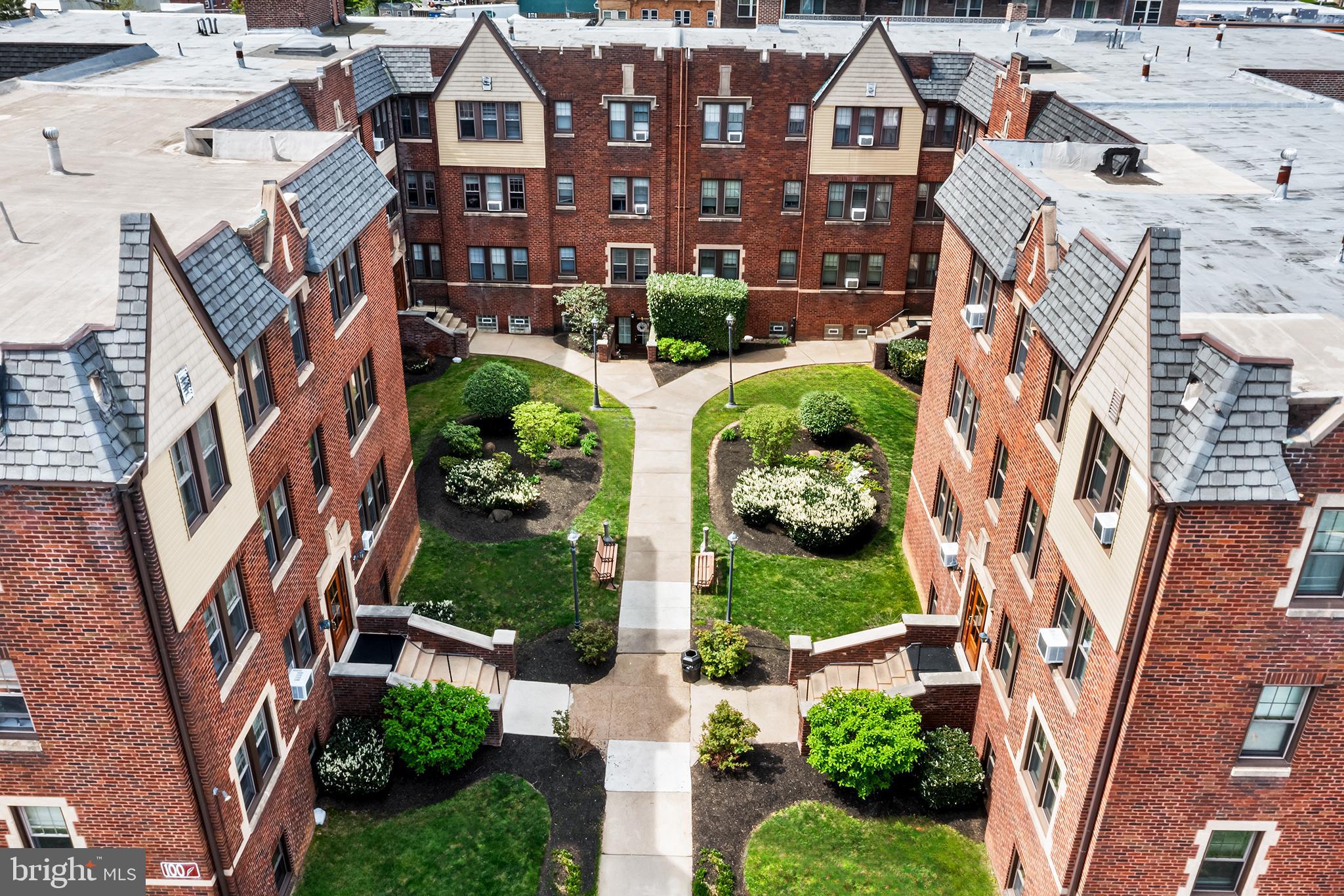 an aerial view of a residential apartment building with a yard and potted plants
