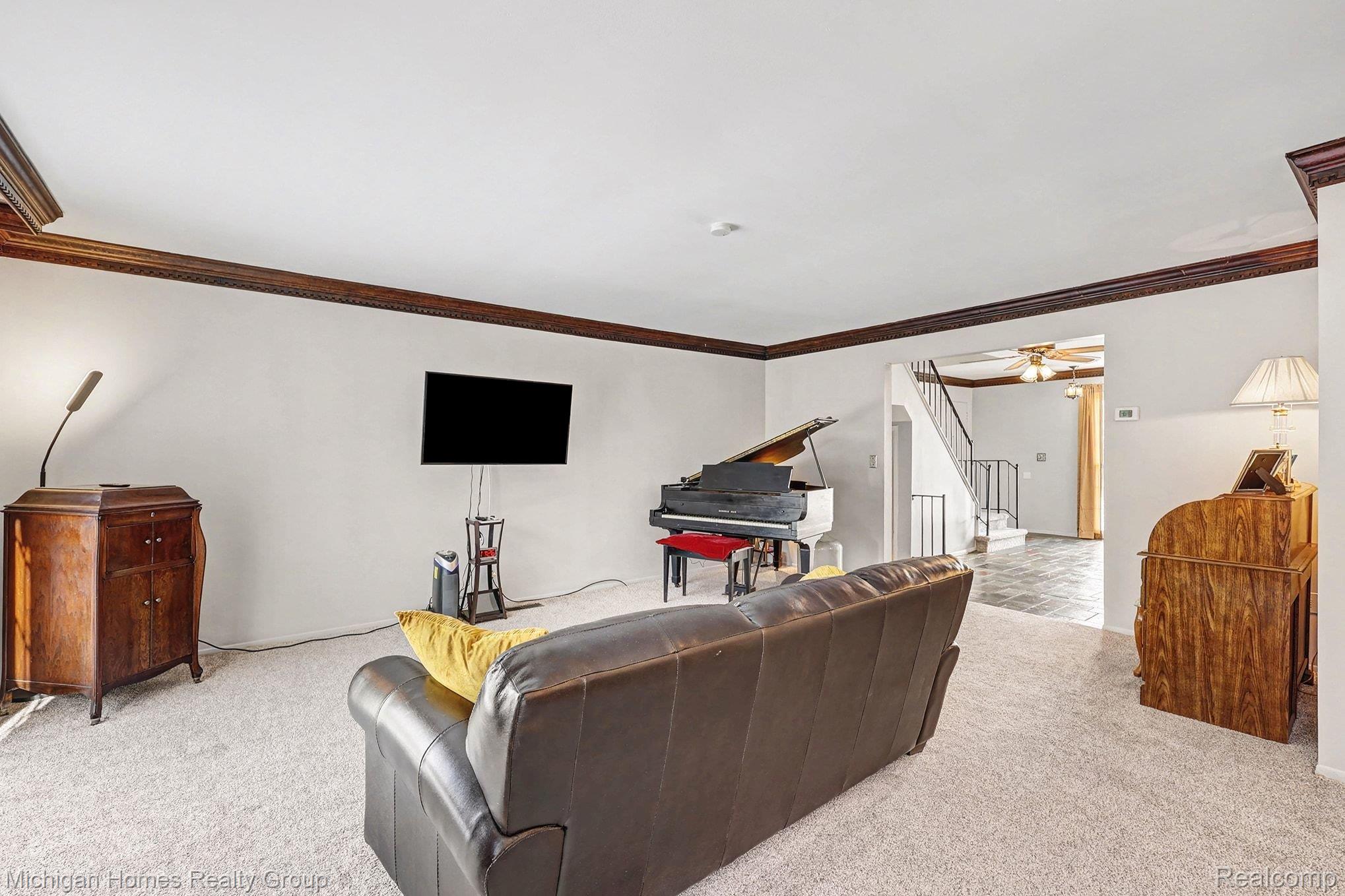 1437 Lantern Lane Rochester, MI 48306 - Photo 14 of 31 Living room featuring light carpet, ceiling fan, and crown molding