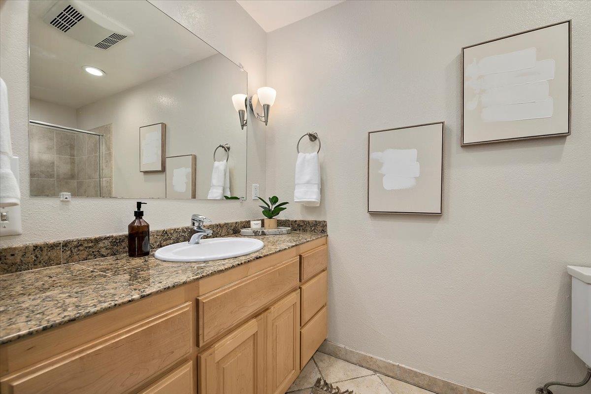 15251 Old Ranch Road Los Gatos, CA 95033 - Photo 17 of 38 a bathroom with a granite countertop sink and a mirror