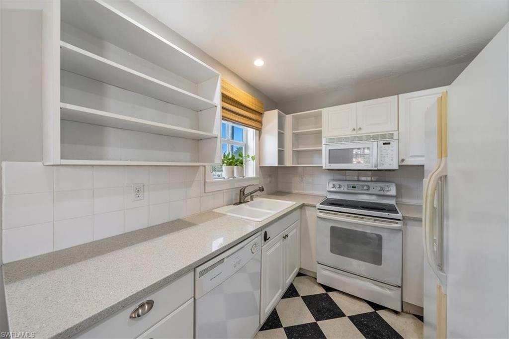 1984 Frederick Street Naples, FL 34112 - Photo 13 of 25 a kitchen with a sink stove and cabinets