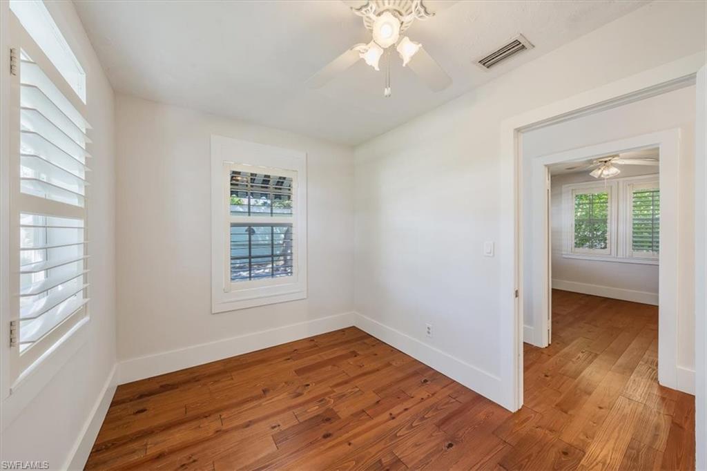 1984 Frederick Street Naples, FL 34112 - Photo 15 of 25 an empty room with wooden floor chandelier fan and windows