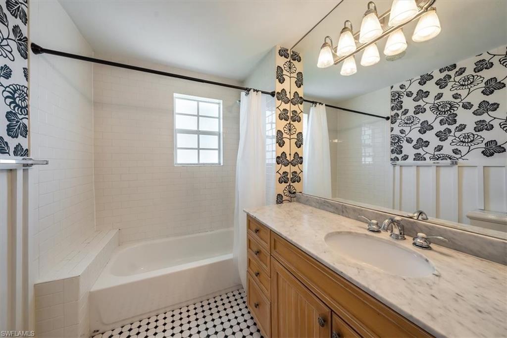 1984 Frederick Street Naples, FL 34112 - Photo 16 of 25 a bathroom with a granite countertop sink a large mirror and shower